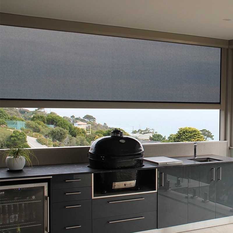 Dark mesh screen over an outdoor kitchen looking toward the landscape.