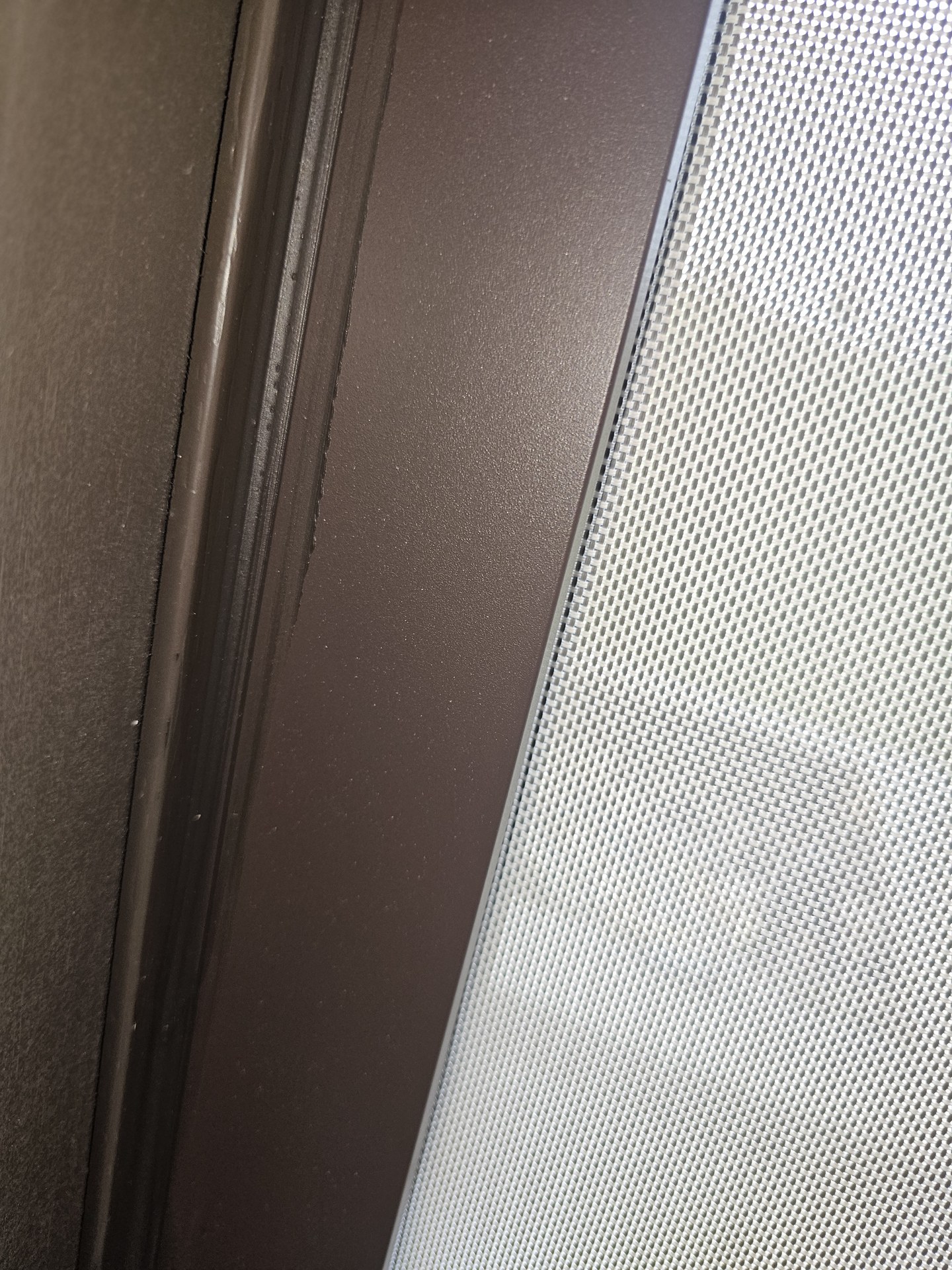 Close detail of screen mesh seated in the frame track.