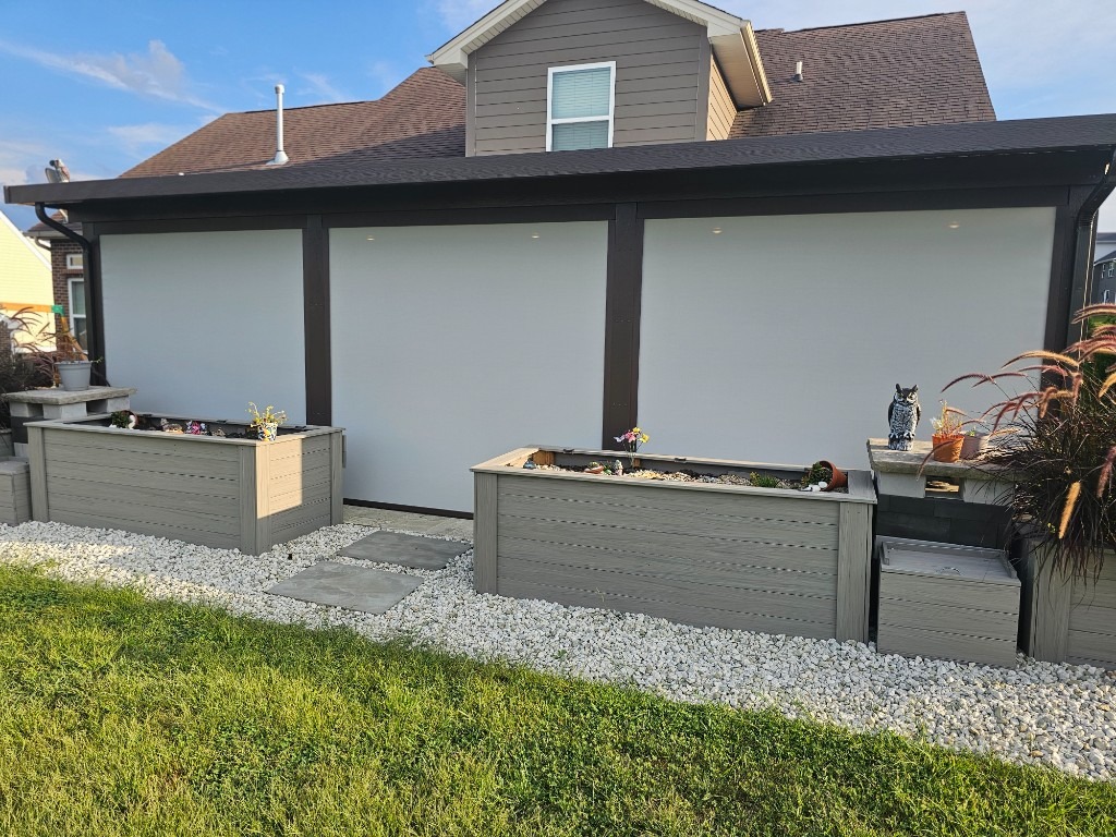 Three fully lowered patio screens on a covered residential porch.