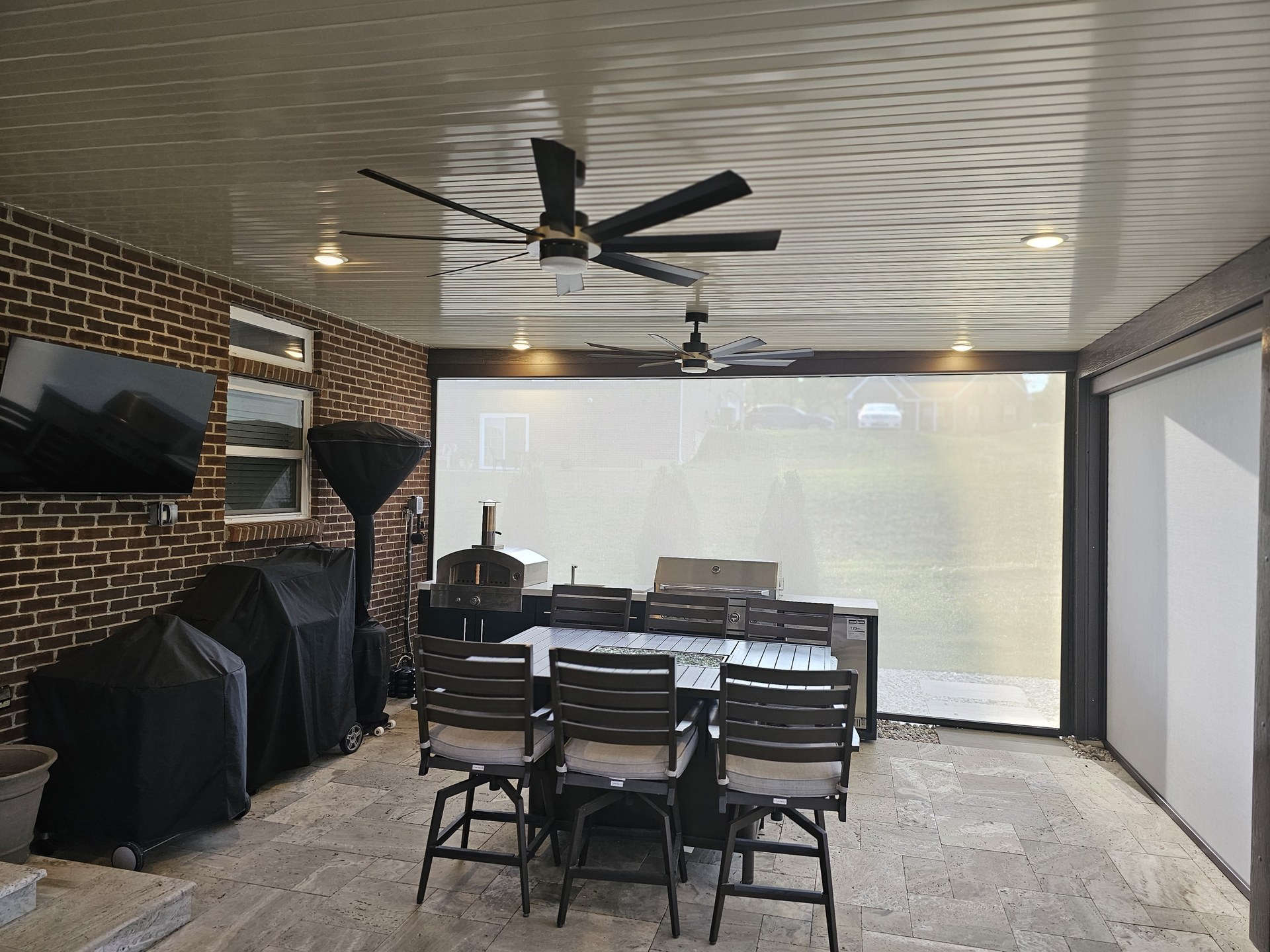 Clark patio project with outdoor kitchen, dining, and motorized screens.