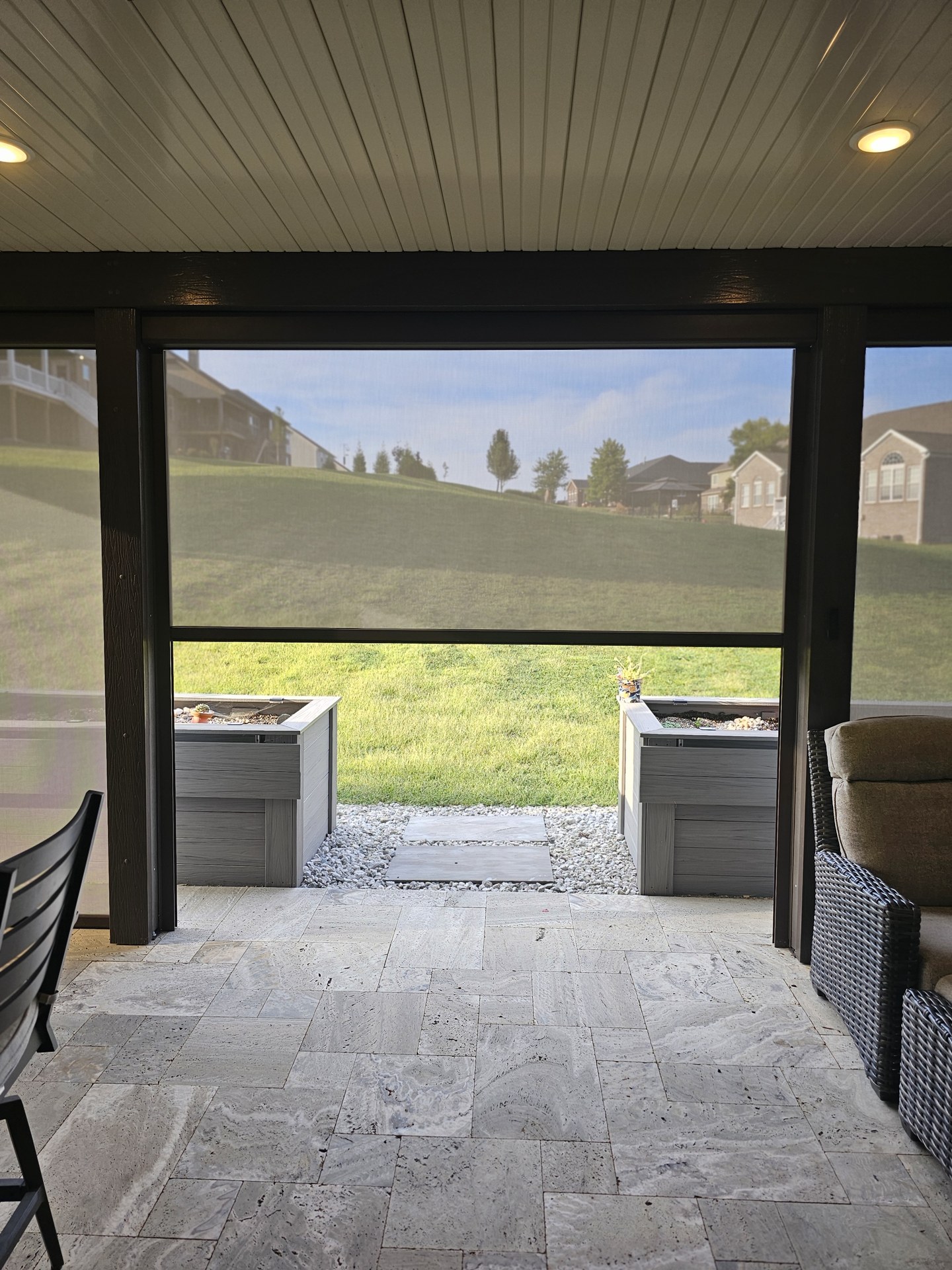 A patio screen in motion across a stone outdoor living space.