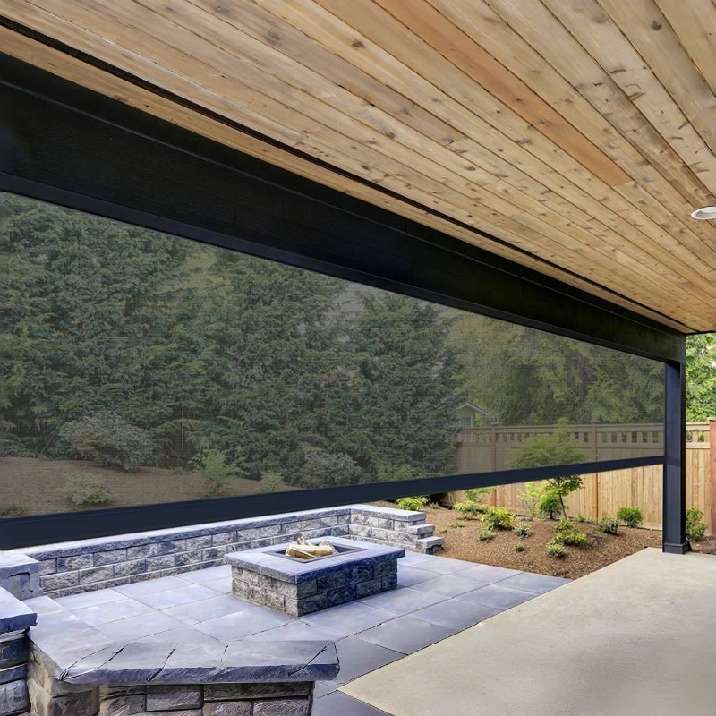 A dark patio screen partially lowered over a stone fire pit.